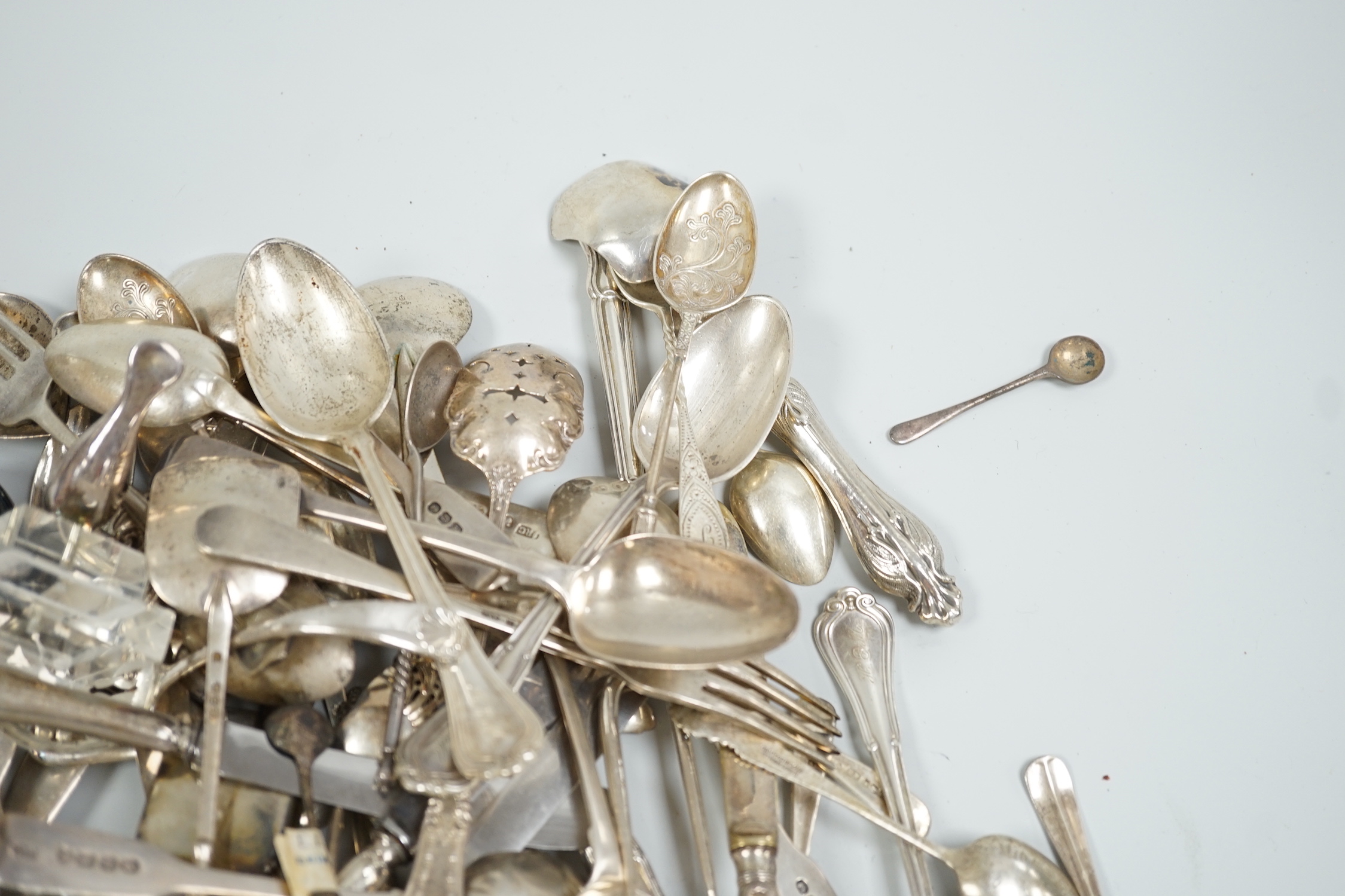 Sundry silver and white metal flatware including a George III silver Old English pattern basting spoon, London, 1782, teaspoons, condiments spoons, sifter spoon, caddy spoon etc.